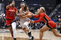 UConn guard Nika Muhl cuts between Dayton guard Anyssa Jones (3) and Dayton guard Ivy Wolf in the second half of an NCAA college basketball game, Wednesday, Nov. 8, 2023, in Hartford, Conn. (AP Photo/Jessica Hill)
