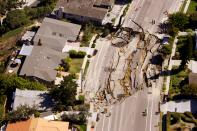 A massive, approximately 200' x 240', sinkhole opens up and tears apart the pavement of Soledad Mountain Road, October 3, 2007 in the Mount Soledad neighborhood of La Jolla near San Diego, California. The landslide has damaged or destroyed reportedly 6 homes and forced the evacuation of at least 20 others. (Photo by Kent Horner/Getty Images)