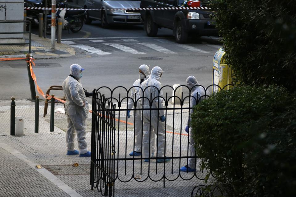 Greek forensic experts search at the scene after an explosion outside the Orthodox church of Agios Dionysios in the upscale Kolonaki area of Athens, Thursday, Dec. 27, 2018. Police in Greece say an officer has been injured in a small explosion outside a church in central Athens while responding to a call to investigate a suspicious package. (AP Photo/Thanassis Stavrakis)