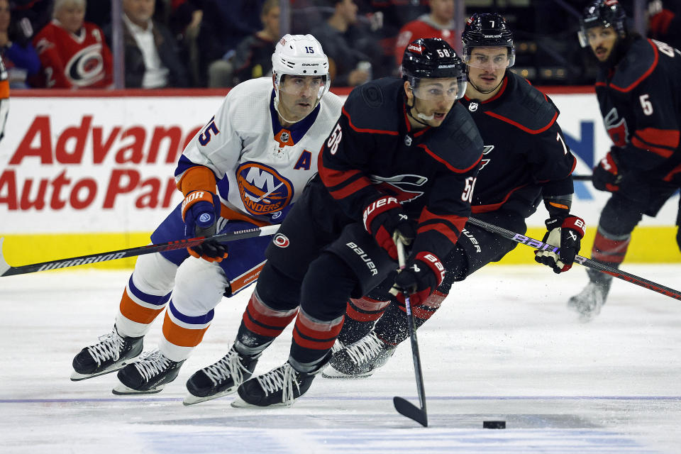 Carolina Hurricanes' Michael Bunting controls the puck after taking it away from New York Islanders' Cal Clutterbuck during the second period of an NHL hockey game in Raleigh, N.C., Thursday, Nov. 30, 2023. (AP Photo/Karl B DeBlaker)