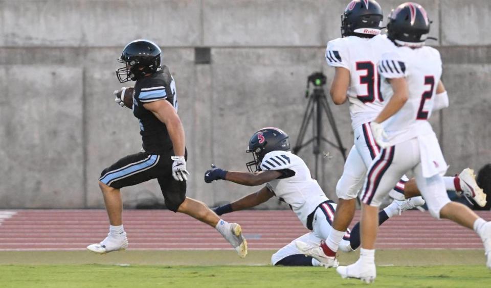 Clovis North’s Jackson Cinfel, left, breaks tackles while running for a touchdown against Memorial during their game at Veterans Memorial Stadium in Clovis on Friday, Aug. 18, 2023.