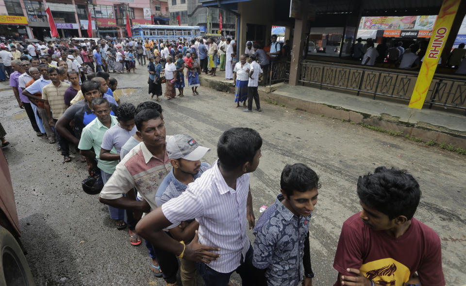 In this Oct. 22, 2019 photo, supporters of Sri Lanka's presidential candidate and former defense chief Gotabaya Rajapaksa queue up to enter a rally in Neluwa, Sri Lanka. Sri Lankans will be voting Saturday for a new president after weeks of campaigning that largely focused on national security and religious extremism in the backdrop of the deadly Islamic State-inspired suicide bomb attacks on Easter Sunday. (AP Photo/Eranga Jayawardena)