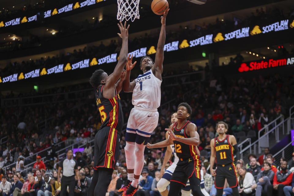 Minnesota Timberwolves guard Anthony Edwards (1) shoots past Atlanta Hawks Clint Capela, left, De'Andre Hunter (12) and Trae Young (11) in the second half of an NBA basketball game, Monday, March 13, 2023, in Atlanta. (AP Photo/Brett Davis)