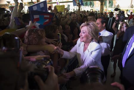 Democratic U.S. presidential candidate Hillary Clinton greets supporters with U.S. Department of Housing and Urban Development Secretary Julian Castro (R-rear) at her side at the conclusion of a "Latinos for Hillary" rally in San Antonio, Texas October 15, 2015. REUTERS/Darren Abate