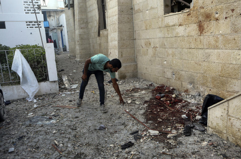 A Palestinian man inspects the damage at al-Ahli hospital, in Gaza City, Wednesday, Oct. 18, 2023. The Hamas-run Health Ministry says an Israeli airstrike caused the explosion that killed hundreds at al-Ahli, but the Israeli military says it was a misfired Palestinian rocket. (AP Photo/Abed Khaled)