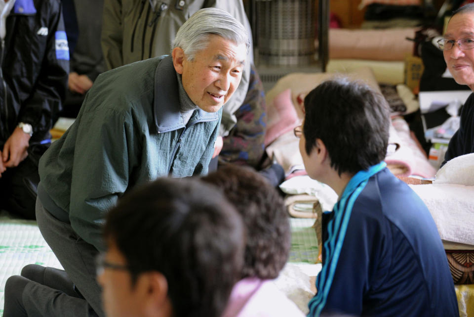 FILE - In this May 6, 2011, file photo, Emperor Akihito kneels down as he speaks with a woman during his visit to a refugee center in Kamaishi, a city severely damaged by the March 11 earthquake and tsunami, in Iwate Prefecture, northeastern Japan. The outpouring of emotion was earned through much smaller moments, such as his visit in 2011, wearing a windbreaker instead of his usual suit, to see victims of a massive earthquake, tsunami and nuclear meltdown. (Kyodo News via AP, File)