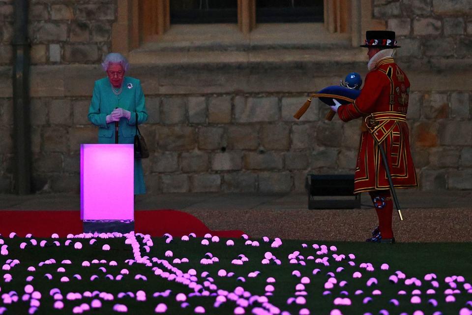 Britain's Queen Elizabeth II receives the Commonwealth Nations Globe to start the lighting of the Principal Beacon outside of Buckingham Palace in London, from the Quadrangle at Windsor Castle in Windsor, west of London, on June 2, 2022, as part of Platinum Jubilee celebrations.