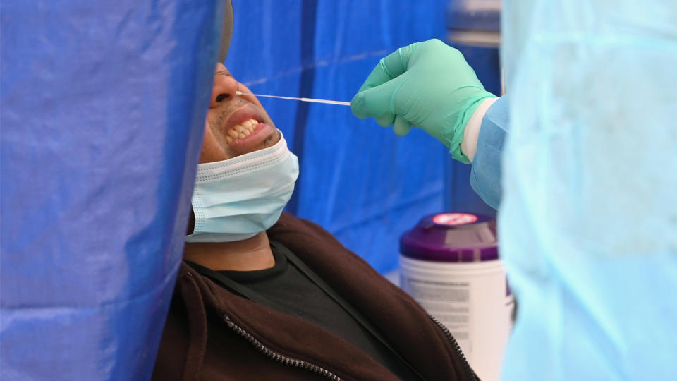 A man flinches as a health care worker takes a nasal swab during a coronavirus test at a pop-up testing site in Brooklyn in May.