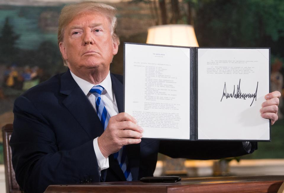 US President Donald Trump signs a document reinstating sanctions against Iran after announcing the US withdrawal from the Iran Nuclear deal, in the Diplomatic Reception Room at the White House in Washington, DC, on May 8, 2018.