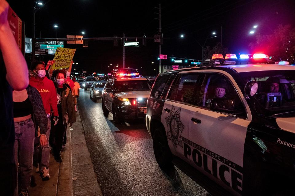 Police officers look outside their car window as people march in a Black Lives Matter rally in downtown Las Vegas on June 1. (Photo: BRIDGET BENNETT via Getty Images)