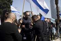 An Israeli police officer pushes a protester to step off of a main road as high-tech workers protest Israel's right-wing government in Tel Aviv, Tuesday, Israel, Jan. 24, 2023. As Israel's new government pushes ahead with its far-right agenda, the tech industry is speaking out in unprecedented criticism against policies it fears will drive away investors and decimate the booming sector, Israel. (AP Photo/ Maya Alleruzzo)