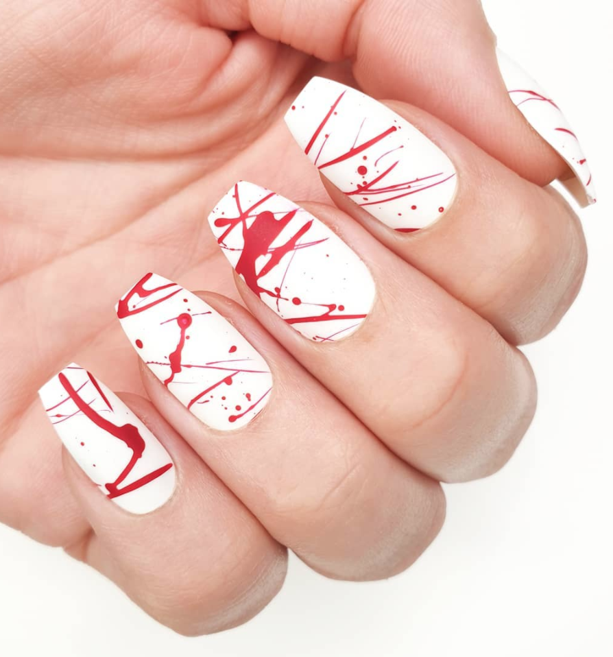 <p>Get <a href="https://www.instagram.com/p/B4DX1F2ApzY/" rel="nofollow noopener" target="_blank" data-ylk="slk:nail artist Ceri's blood splatter look" class="link ">nail artist Ceri's blood splatter look</a> by starting with a white nail polish for the base, and layering strokes of red paint on top. </p><p><a class="link " href="https://go.redirectingat.com?id=74968X1596630&url=https%3A%2F%2Fwww.etsy.com%2Flisting%2F725499136%2Fblood-splatter-halloween-gluepress-on&sref=https%3A%2F%2Fwww.oprahdaily.com%2Fbeauty%2Fskin-makeup%2Fg33239588%2Fhalloween-nail-ideas%2F" rel="nofollow noopener" target="_blank" data-ylk="slk:SHOP PRESS ON NAILS">SHOP PRESS ON NAILS</a></p>