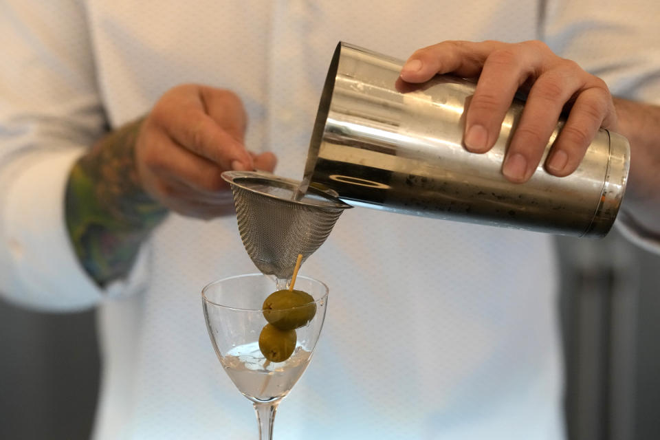 Bartender Brian McGee demonstrates how to make a Dirty Gin Martini with two olives at the Koval Distillery's tasting room Wednesday, Feb. 8, 2023, in Chicago. Spirits have surpassed beer for U.S. market share supremacy, led by a resurgent cocktail culture including the popularity of ready-to-drink concoctions according to the Distilled Spirits Council of the United States. (AP Photo/Charles Rex Arbogast)