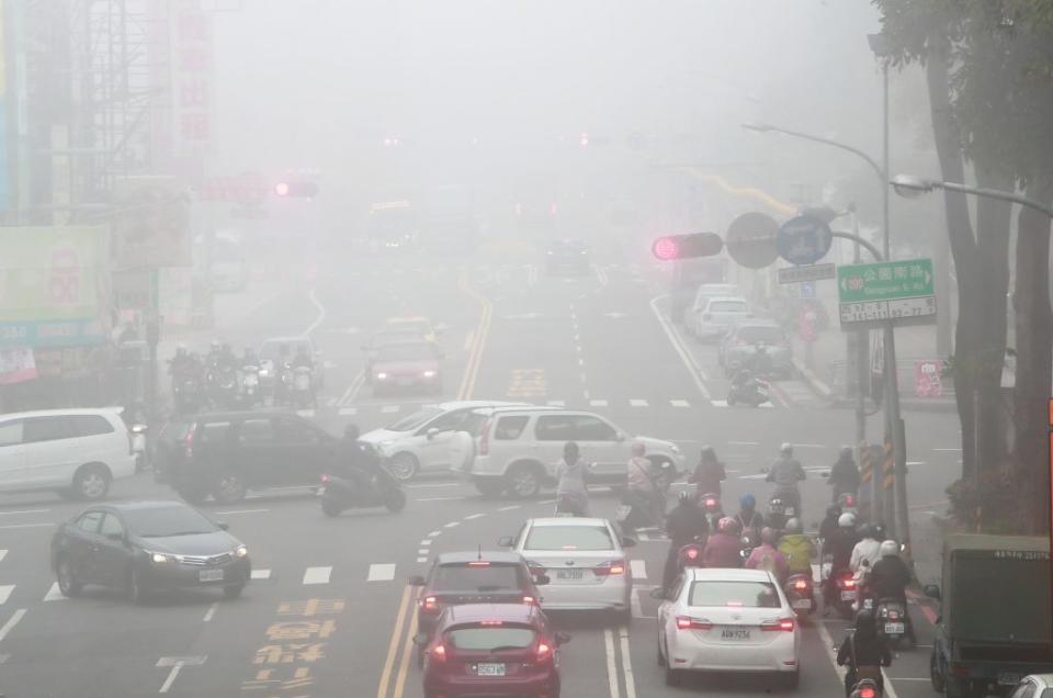 台灣西半部空品亮紅燈，台南市八日天空灰濛濛，路上行車距離稍遠處幾乎看不到了。（記者趙傳安攝）