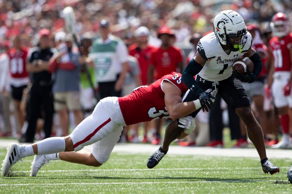 Miami (Oh) Redhawks linebacker Ryan McWood (35) takes down Cincinnati Bearcats wide receiver Tre Tucker (1) during the second quarter of the NCAA football game between the Cincinnati Bearcats and the Miami RedHawks at Paycor Stadium in Cincinnati on Saturday, Sept. 17, 2022. The Cincinnati Bearcats defeated the Miami (Oh) Redhawks 38-17 in the 126th Battle for the Victory Bell. 