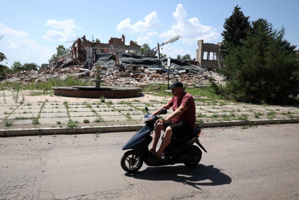 A local resident rides a scooter through the destroyed central square of Hulyaypole, Zaporizhzhia Region (AFP via Getty Images)