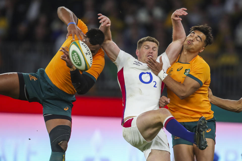 England's Owen Farrell, centre, competes for the ball with Australia's Samu Kerevi, left, and Jordan Petaia during the rugby international between England and the Wallabies in Perth, Australia, Saturday, July 2, 2022. (AP Photo/Gary Day)