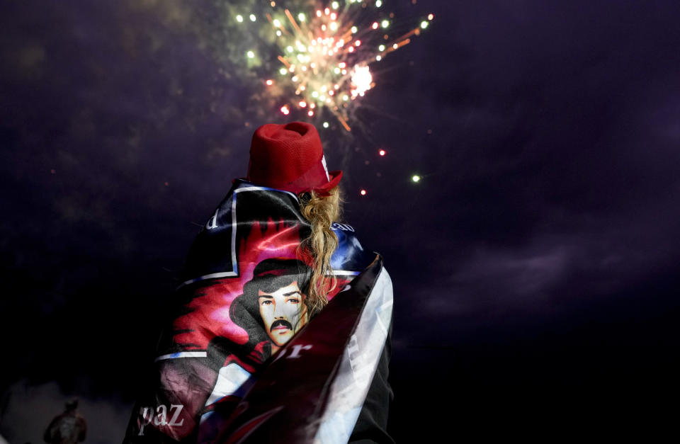 A woman watches fireworks at the sanctuary of Argentina's folk Saint "Gauchito" Gil in Mercedes, Corrientes, Argentina, Monday, Jan. 8, 2024. Every Jan. 8, devotees from across the country visit his sanctuary to ask for miracles or give him thanks.(AP Photo/Natacha Pisarenko)