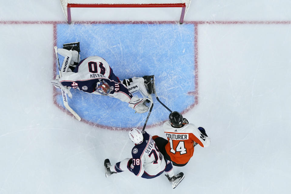 Columbus Blue Jackets' Daniil Tarasov (40) catches the puck past Damon Severson (78) and Philadelphia Flyers' Sean Couturier (14) during the second period of an NHL hockey game, Thursday, Jan. 4, 2024, in Philadelphia. (AP Photo/Matt Slocum)