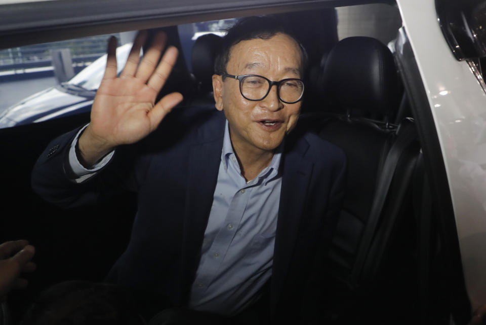 Cambodia's exiled opposition leader Sam Rainsy waves as he gets in a car after arriving at Kuala Lumpur International's Airport in Sepang, Malaysia Saturday, Nov. 9, 2019. Sam Rainsy landed in Kuala Lumpur in a bid to return to his homeland after Thailand had earlier blocked him from entering. (AP Photo/Vincent Thian)