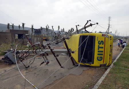 Power lines and a passenger bus are seen after being damaged by strong winds caused by Cyclone Hudhud in Visakhapatnam October 13, 2014. REUTERS/R Narendra