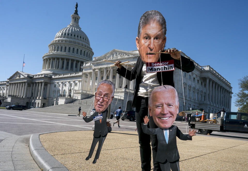 A climate change demonstrator mocks Sen. Joe Manchin, D-W.Va., who has blocked President Joe Biden's domestic agenda, at the Capitol in Washington, Wednesday, Oct. 20, 2021. (AP Photo/J. Scott Applewhite)