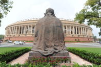 A Mahatma Gandhi statue overlooks the Parliament building as law makers arrive in New Delhi, India, Monday, Sept.14, 2020. Indian lawmakers have returned to Parliament after more than five months even as coronavirus cases continue to surge at the fastest pace than anywhere else in the world. (AP Photo)