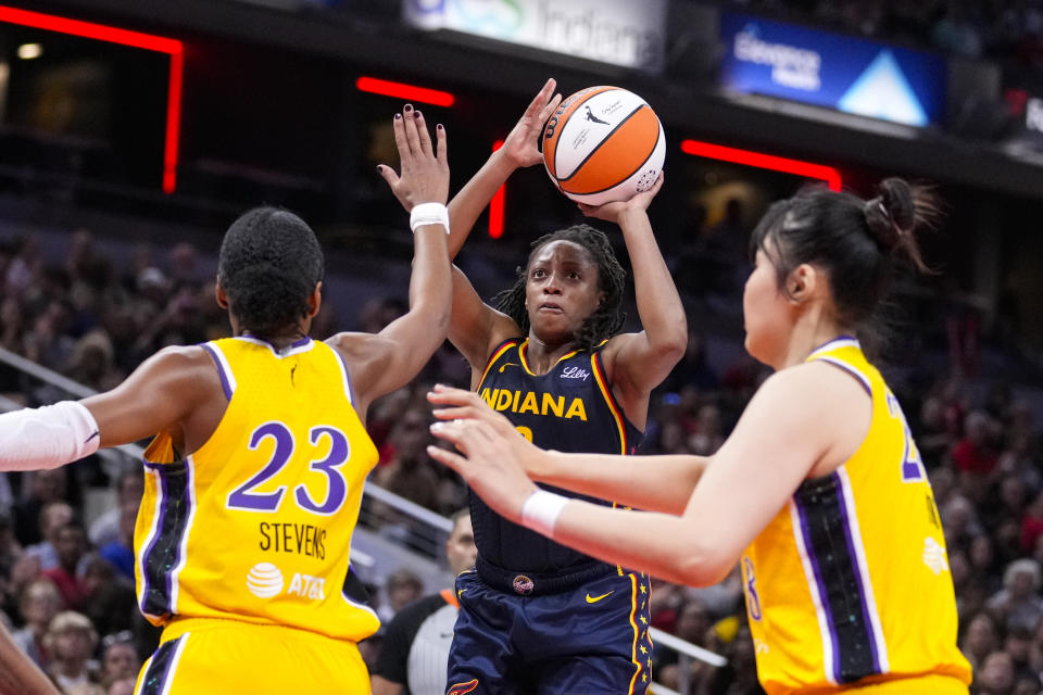 Indiana Fever guard Kelsey Mitchell (0) shoots between Los Angeles Sparks forward Azura Stevens (23) and center Li Yueru (28) in the second half of a WNBA basketball game in Indianapolis, Wednesday, Sept. 4, 2024. (AP Photo/Michael Conroy)