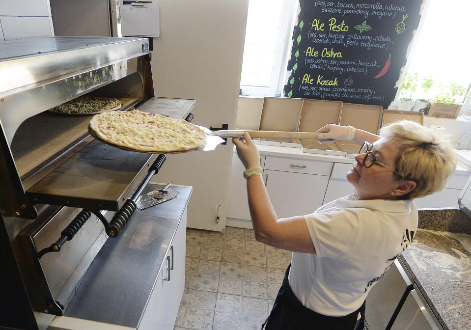 In this photo taken March 18, 2020, Bozena Legowska is making free pizzas for the doctors and medics of the Bielany hospital in Warsaw, Poland, as part of a nationwide action in a gesture of support for their unstopping fight against the spreading coronavirus. Restaurants and eateries remain closed to the public under a "national quarantine" aimed at breaking the human transmission belt for the virus, but they can do deliveries. (AP Photo/Czarek Sokolowski)