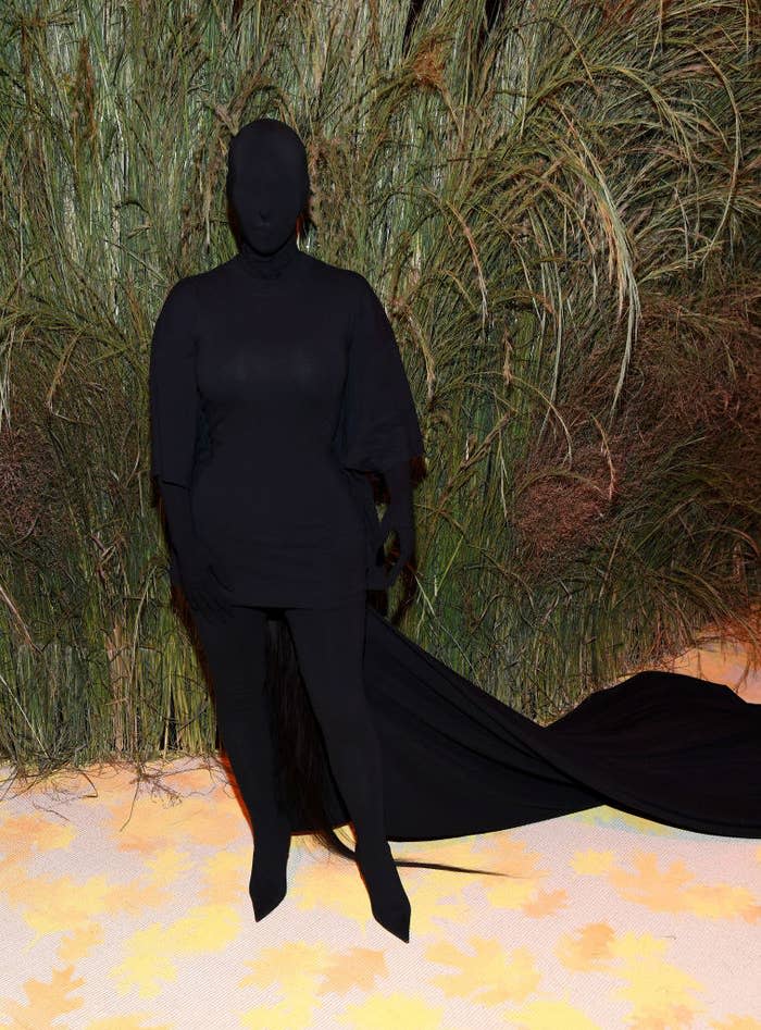 Kim wore a dark long-sleeved dress with matching gloves, tights, and boots and cape. She also wore a full head covering in the same material so that the entire outfit made her look like a shadow