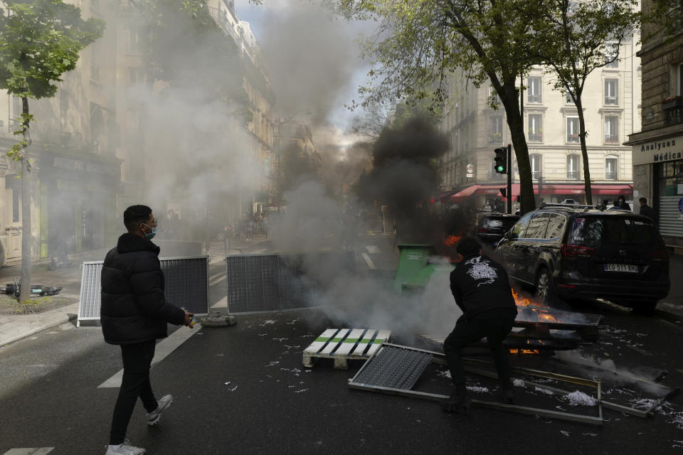 Youths stand by a barricade during a banned protest in support of Palestinians in the Gaza Strip, in Paris, Saturday, May, 15, 2021. Marches in support of Palestinians in the Gaza Strip were being held Saturday in a dozen French cities, but the focus was on Paris, where riot police got ready as organizers said they would defy a ban on the protest. (AP Photo/Rafael Yaghbozadeh)