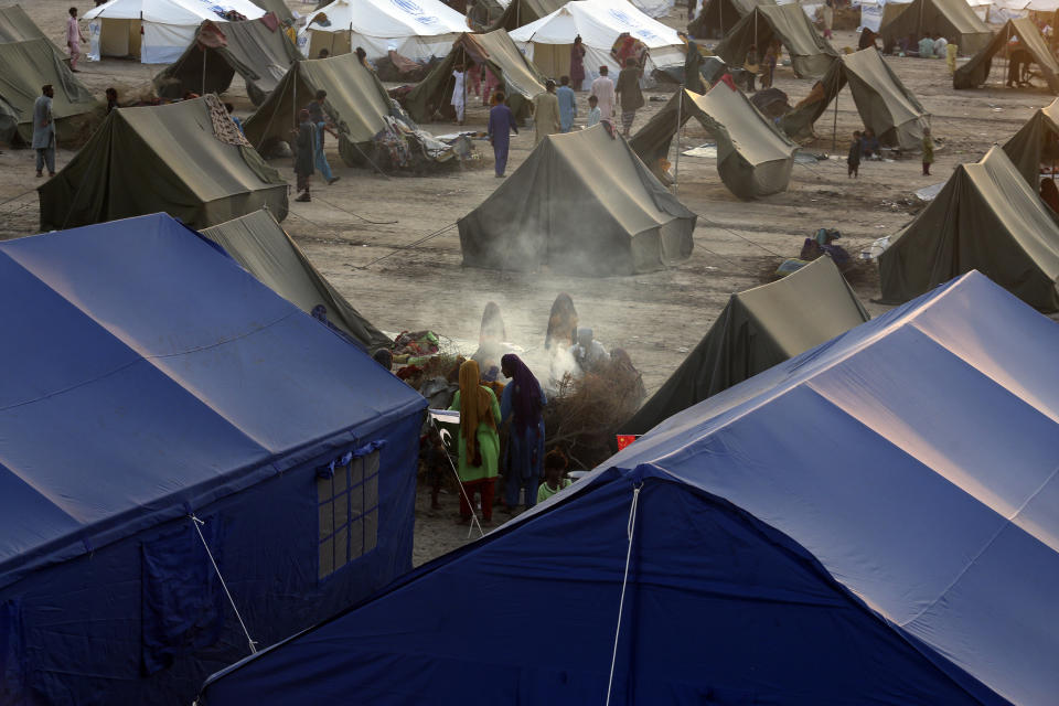 Victims of heavy flooding from monsoon rains take refuge as they prepare tea at a temporary tent housing camp organized by the UN Refugee Agency (UNHCR), in Sukkur, Pakistan, Saturday, Sept. 10, 2022. Months of heavy monsoon rains and flooding have killed over a 1000 people and affected 3.3 million in this South Asian nation while half a million people have become homeless. (AP Photo/Fareed Khan)