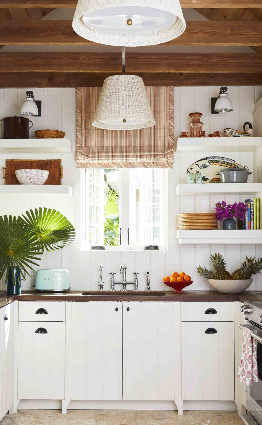 mahogany countertops, abaco pine beams, and vintage wicker pendant shades ground the kitchen in organic island simplicity