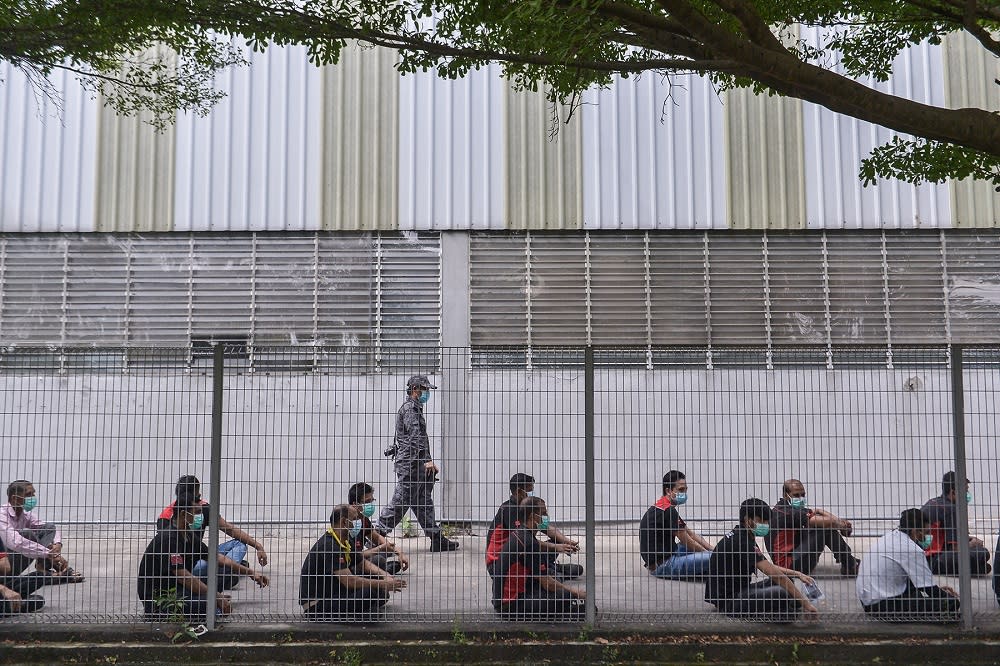 Foreign workers practise social distancing during the Op Patuh and Op Bantu operations at a factory in Shah Alam July 17, 2021. — Picture by Miera Zulyana