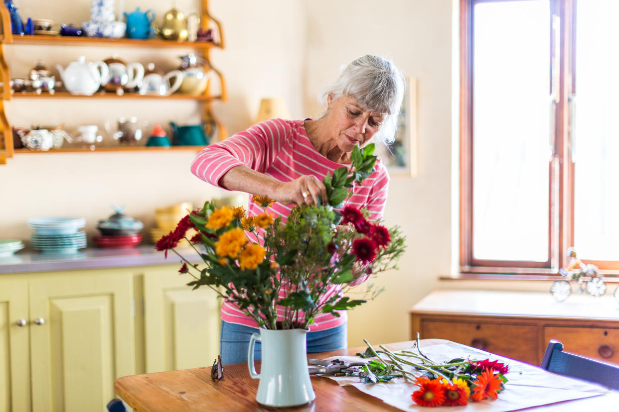 Woman arranging flowers. (Getty Images)