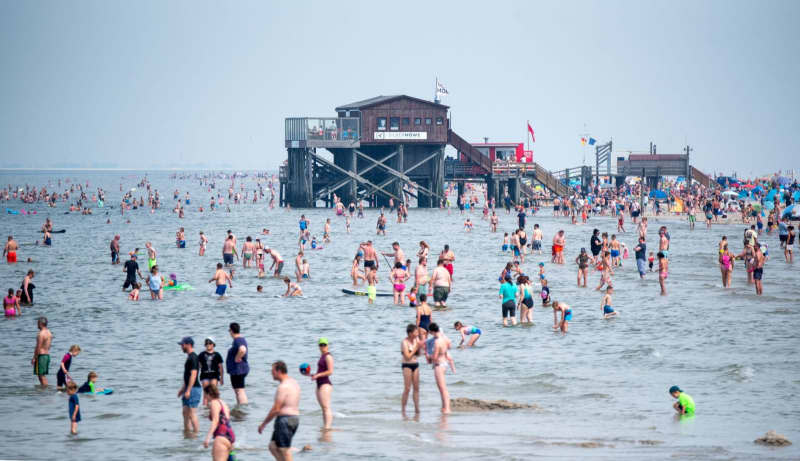 Numerous tourists sunbathe in the North Sea.  Daniel Bockwoldt/dpa