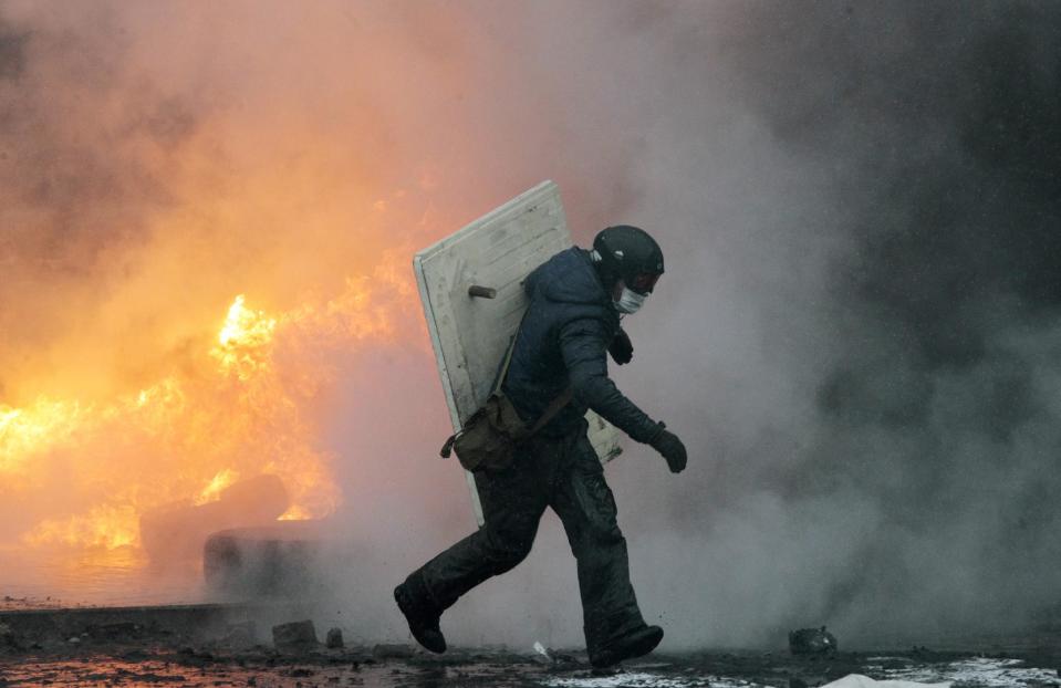 Protesters clash with police in central Kiev, Ukraine, Wednesday, Jan. 22, 2014. Several people have died in clashes between protesters and police in the Ukrainian capital Wednesday, according to medics on the site, in a development that will likely escalate Ukraine's two month-long political crisis. (AP Photo/Sergei Chuzavkov)