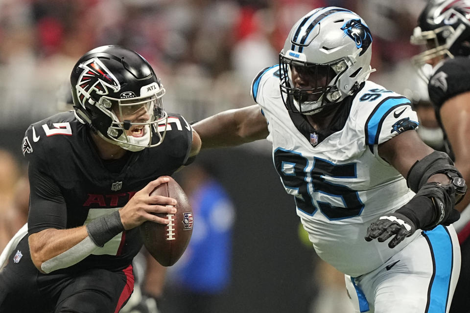 Atlanta Falcons quarterback Desmond Ridder (9) scramles near Carolina Panthers defensive tackle Derrick Brown (95) during the first half of an NFL football game, Sunday, Sept. 10, 2023, in Atlanta. (AP Photo/Brynn Anderson)