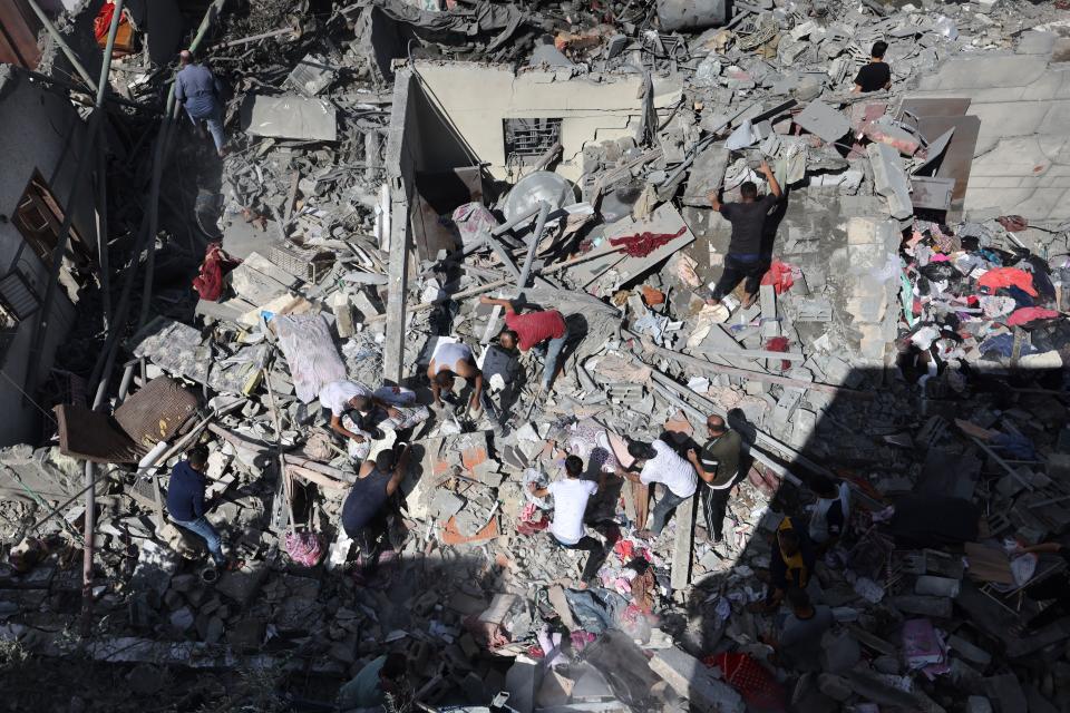 People search for victims among destroyed buildings on Tuesday following an Israeli airstrike on Rafah.