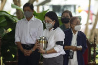 The grandchild of former Philippine President Fidel Ramos, center, carries his urn as she walks in front of Philippine President Ferdinand Marcos Jr. and Amelita Ramos, wife of the former president, during a state funeral at the Heroes' Cemetery in Taguig City, Philippines, Tuesday, Aug. 9, 2022. Ramos was laid to rest in a state funeral Tuesday, hailed as an ex-general, who backed then helped oust a dictatorship and became a defender of democracy and can-do reformist in his poverty-wracked Asian country. (Lisa Marie David/Pool Photo via AP)