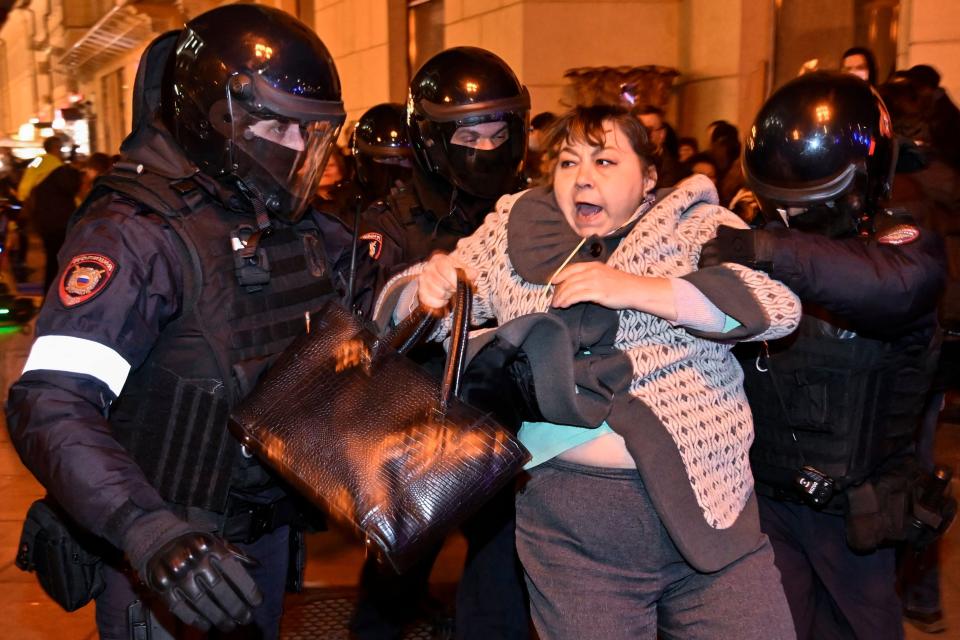 Police officers detain a woman in Moscow (AFP/Getty)