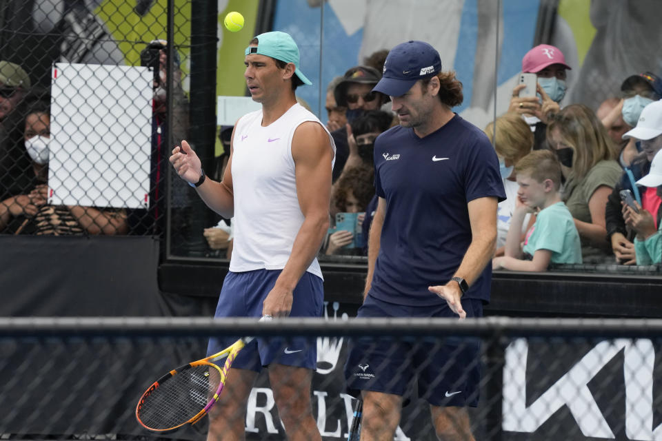 Rafael Nadal of Spain talks with his coach Carlos Moya, right, during a practice session at Melbourne Park at the Australian Open tennis championships in Melbourne, Australia, Saturday, Jan. 29, 2022. Nadal will play Russia's Daniil Medvedev on Sunday Jan. 30 in the men's singles final. (AP Photo/Mark Baker)