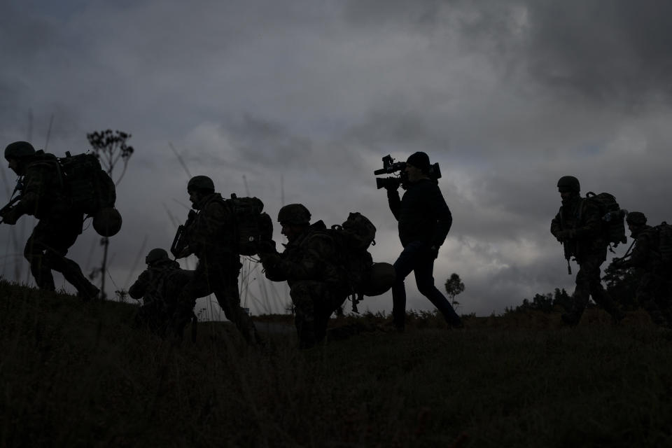 A journalist runs with Ukrainian infantrymen during a training with French soldiers, in France, Tuesday, Nov. 7, 2023. With the full-scale war grinding into a second winter, and casualties already counted in the hundreds of thousands continuing to mount on both sides, the training has become crucially important for Ukraine's chances of victory. (AP Photo/Laurent Cipriani)