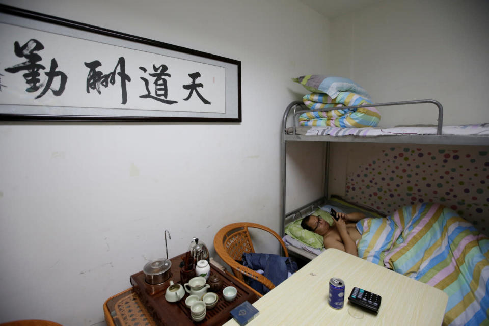 Liu Zhanyu, a client manager at DouMiYouPin, watches a video at a dormitory in the office in Beijing after finishing work at midnight on April 21, 2016. (Jason Lee/Reuters)