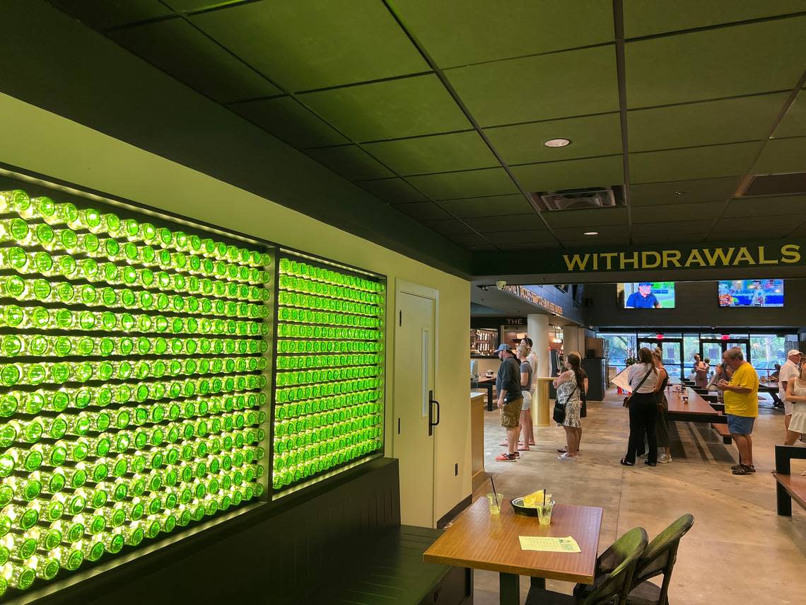 Walls inside The Bank are lined with lighted green bottles.