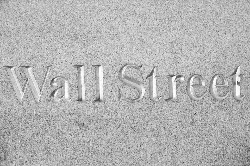 Black and White BW image of Wall Street sign inscription as seen illuminated with light during the night on the road and buildings at Wall St address, downtown in lower Manhattan as the area is a significant famous road and district for the American and the global economy, banking system and markets with the headquarters of companies and financial institutions located there like the New York Stock Exchange NYSE. New York City, USA on May 2023 (Photo by Nicolas Economou/NurPhoto via Getty Images)