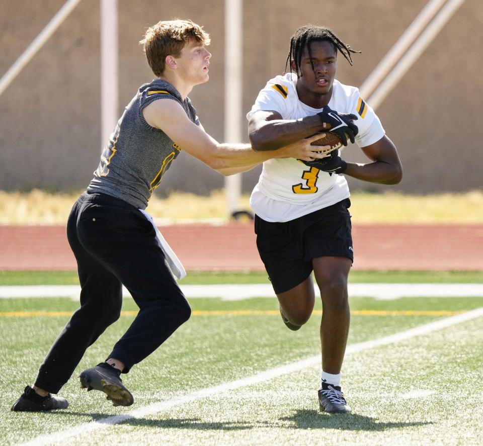 Saguaro quarterback Mason Bray (14) hands the ball off to running back Jaedon Matthews (3) during a spring practice at Saguaro High School in Scottsdale on April 25, 2023.