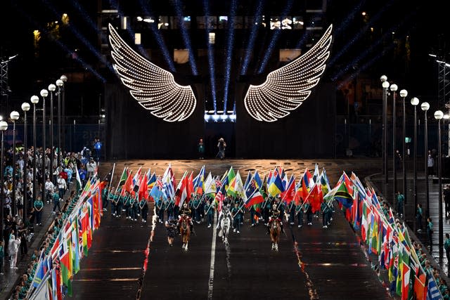 A horsewoman, wearing the flag of the International Olympic Committee, on a metal horse at the Trocadero 