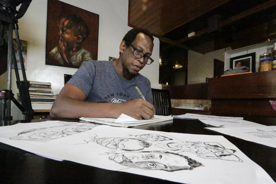 Kenyan cartoonist and commentator Patrick Gathara works on drawing cartoons at his house in Nairobi, Kenya Thursday, Nov. 5, 2020. As the United States twists itself into knots over its most contentious vote in decades, Gathara has spun out a widely read alternate commentary on Twitter, drawing freely from cliches that long have been aimed at elections in Africa. (AP Photo/Khalil Senosi)