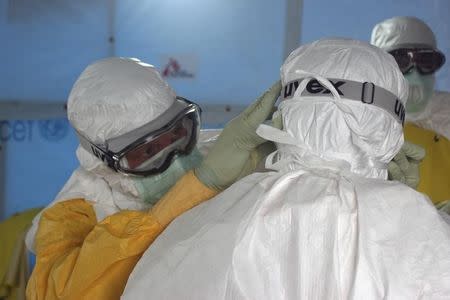 Dr. Joel Montgomery, team leader for the U.S. Centers for Disease Control and Prevention Ebola Response Team in Liberia, is dressed in his personal protective equipment while adjusting a colleague's PPE before entering the Ebola treatment unit in Monrovia, Liberia's capital city in this recent photo released on September 16, 2014. REUTERS/Athalia Christie/CDC/Handout